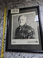 Framed signed photo with measuring tape for scale