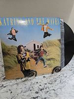 Front jacket of Katrina and The Waves vinyl LP displayed on stand, record partially visible in sleeve