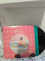 Front jacket art with part of vinyl disc visible