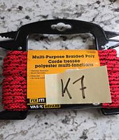 Packaged red braided polyester rope showing product label and 50 ft length