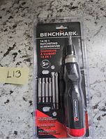 Front view of sealed Benchmark 14-in-1 ratcheting screwdriver set showing handle, bits, and packaging details