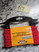 Red braided poly rope on black plastic winder with packaging showing specs