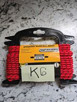 Packaged red polyester rope showing length, diameter, workload and brand