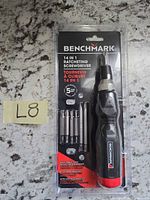 Front view of sealed Benchmark 14-in-1 ratcheting screwdriver set showing handle and bits in blister pack
