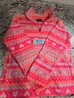 Front view of pink/orange patterned fleece pullover with tag and size note