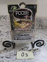 Front view of sealed Foose Design ’56 Chevy Nomad die-cast car on stand with lot number