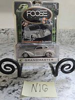 Front view of sealed Foose Grandmaster die-cast car in packaging