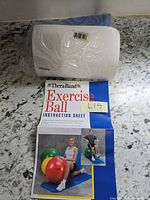 Overall view of sealed package containing folded blue exercise ball and instruction sheet