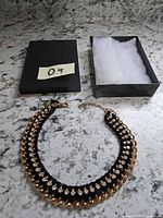 Necklace with gift box and padding displayed on countertop