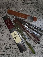 Full kit showing tin, wooden holder, bundled incense sticks, metal lid