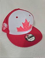 Three-quarter view of hat showing maple-leaf logo, colour scheme, 9Fifty sticker