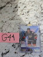 Front view of serial-numbered Ryan Getzlaf Trilogy card in holder with lot tag