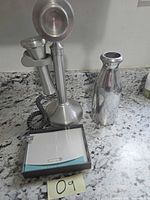 Thank you cards, candlestick phone, silver vase on countertop