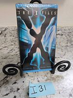 Front view of sealed The X-Files VHS tape on stand