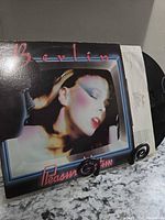 Front cover and vinyl partially visible on stand