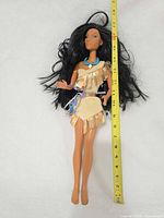Full view of doll with measuring tape showing height
