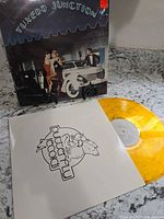 Front jacket standing, yellow vinyl partly out of white Butterfly Records sleeve