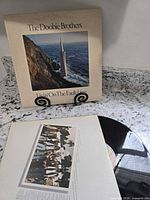 Front jacket displayed upright and vinyl partially out on countertop