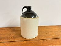 Front view of the stoneware crock jug showing cream body, dark brown glazed top and handle