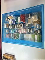 Tray containing numerous sealed bags of assorted glass beads