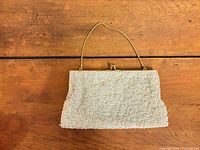 Front view of beaded evening purse with handle visible