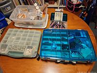 Overview of three storage cases and pliers on table