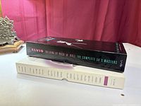 Side view showing spine titles of Elvis and Patsy Cline CD box sets stacked