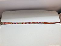 Full view of brown leather belt with colourful beaded design and buckle