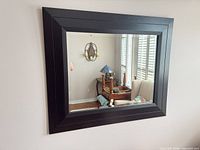 Front view of rectangular mirror mounted on wall; shows full frame and reflective surface