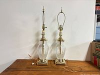 Full view of both crystal table lamps with harps, finials, bases and cords