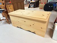 Closed pine blanket box showing exterior, scalloped base