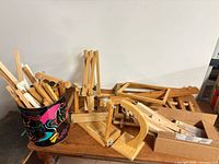 Overview of all wooden quilting frame components and decorative bucket on table