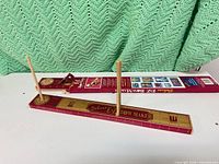 Two Deluxe EZ BowMaker boards, one boxed, one loose with pegs inserted