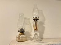 Two oil lamps side by side showing overall form and height difference