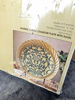 Retail box showing image and details of charger plate