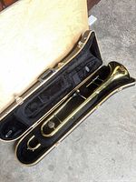 Trombone in open hard case showing overall instrument and interior lining