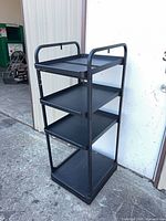 Full view of black four-tier metal shelf unit front angle