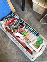 Bin with multiple wrapping paper rolls, bags, bows and tags