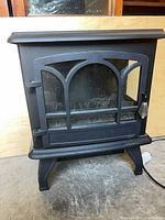 Front view of black steel electric fireplace heater