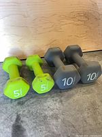 Front view of all four dumbbells showing weights and colors