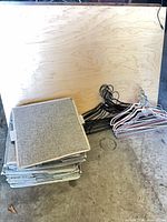 Stack of folded fabric organizers, wire hangers beside