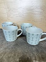 Four mugs front view showing exterior pattern and handles