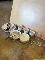Full lot with plates, bowls, mugs, glasses and cutlery grouped together