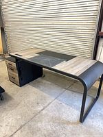 Full view of desk showing top surface, metal legs and pedestal