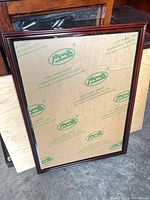 Front view showing wood frame and acrylic panel with protective film