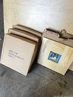Stack of cardboard-boxed frames with one frame exposed