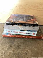 Stacked view of four hardcover cookbooks showing spines