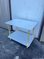 Front angled view of the assembled side table showing top, shelf, and legs