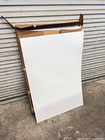Full view of one poster board leaning against shipping carton