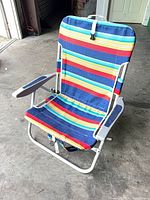 Front view of folded-out RIO beach chair showing rainbow fabric, armrests and frame